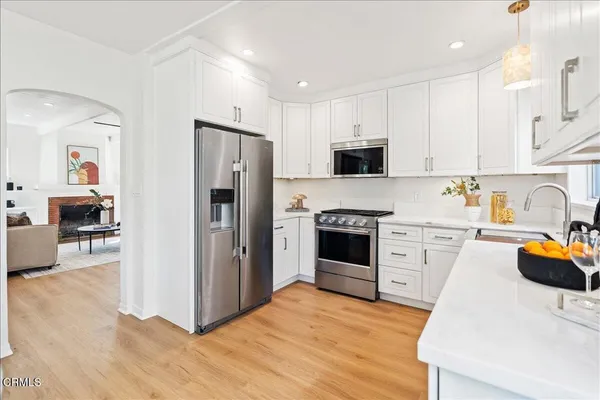 a kitchen with stainless steel appliances a stove refrigerator sink and microwave