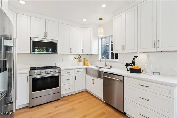 a kitchen with stainless steel appliances granite countertop a stove a sink and a microwave