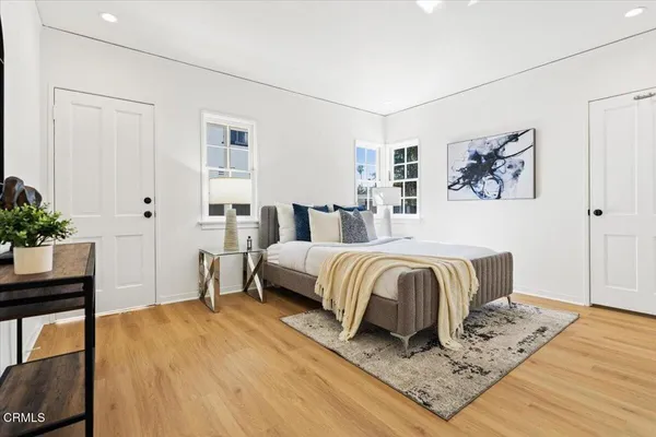 a spacious bedroom with a bed and wooden floor