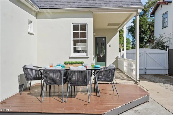 a patio with table and chairs and potted plants