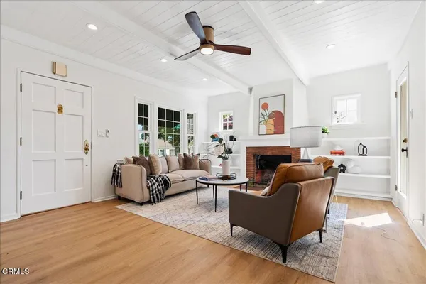 a living room with furniture a fireplace and a ceiling fan