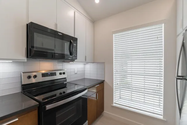 a kitchen with stainless steel appliances a stove microwave and sink