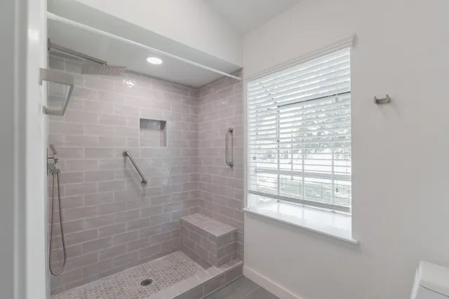 a bathroom with a shower and a window