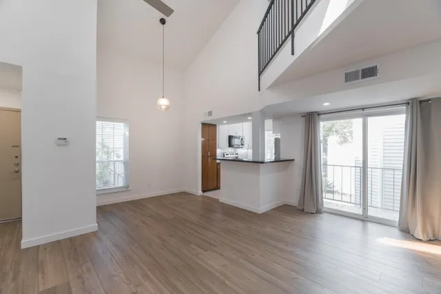 a view of a kitchen with wooden floor and a window