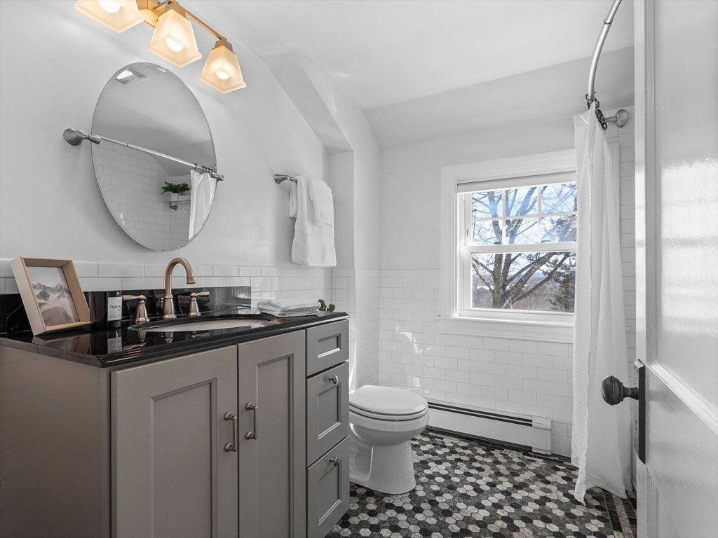 40 Chisholm Road Boston, MA 02131 - Photo 18 of 33 a bathroom with a toilet a sink and mirror