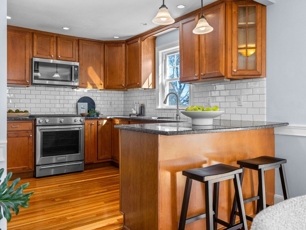 40 Chisholm Road Boston, MA 02131 - Photo 3 of 33 a kitchen with stainless steel appliances granite countertop a stove a sink dishwasher and a microwave oven with cabinets
