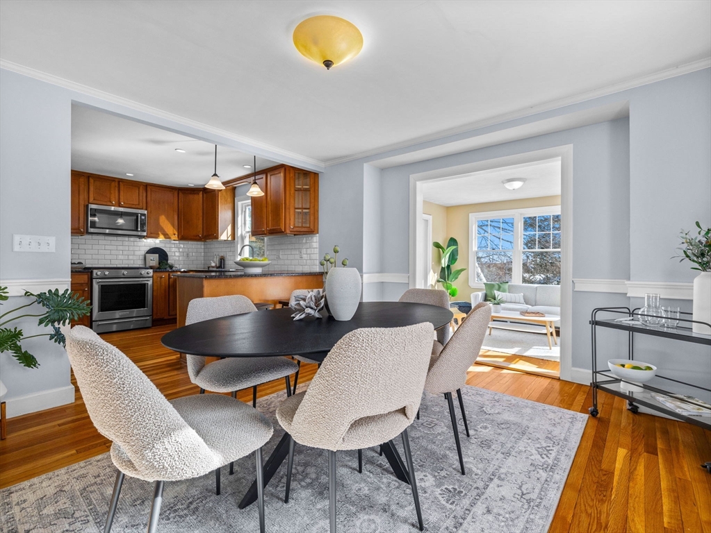 40 Chisholm Road Boston, MA 02131 - Photo 5 of 33 a living room with a couch and a dining table with wooden floor