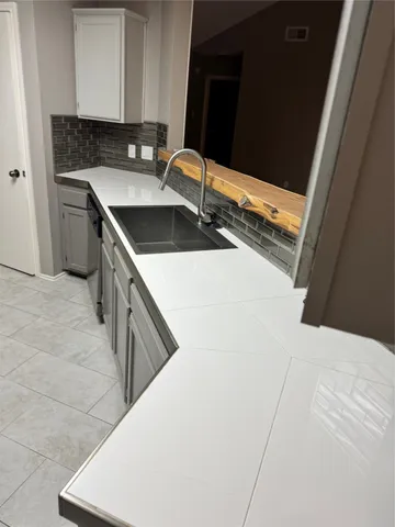 a kitchen with white cabinets and black appliances