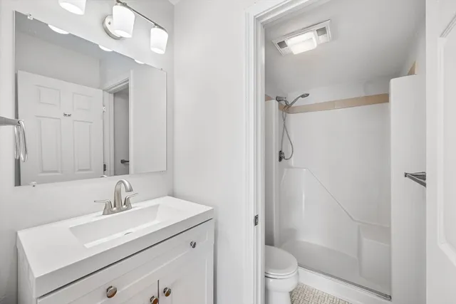 a bathroom with a sink a toilet and shower