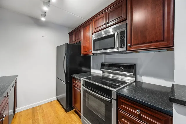 a kitchen with stainless steel appliances granite countertop a stove microwave and refrigerator
