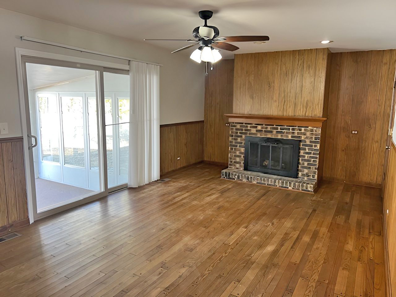 654 Longview Drive Antioch, IL 60002 - Photo 7 of 39 an empty room with wooden floor fireplace and windows