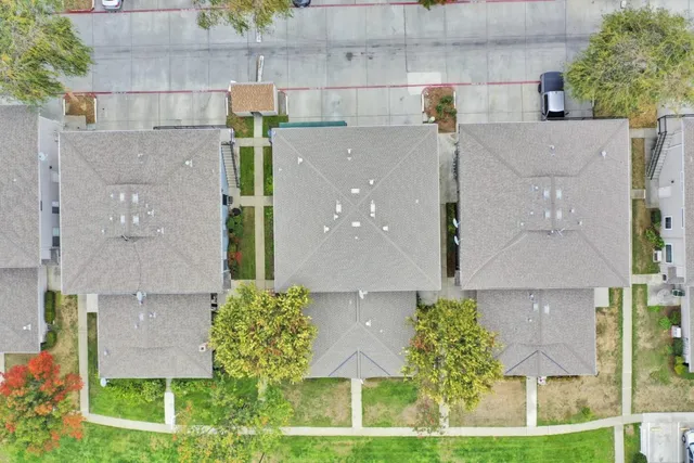 an aerial view of residential houses with outdoor space and a street view