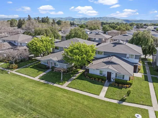 an aerial view of residential houses with outdoor space and city view