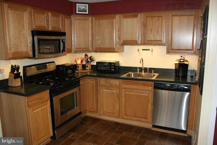 8124 Cornwall Road Baltimore, MD 21222 - Photo 8 of 29 a kitchen with granite countertop a sink a stove and cabinets
