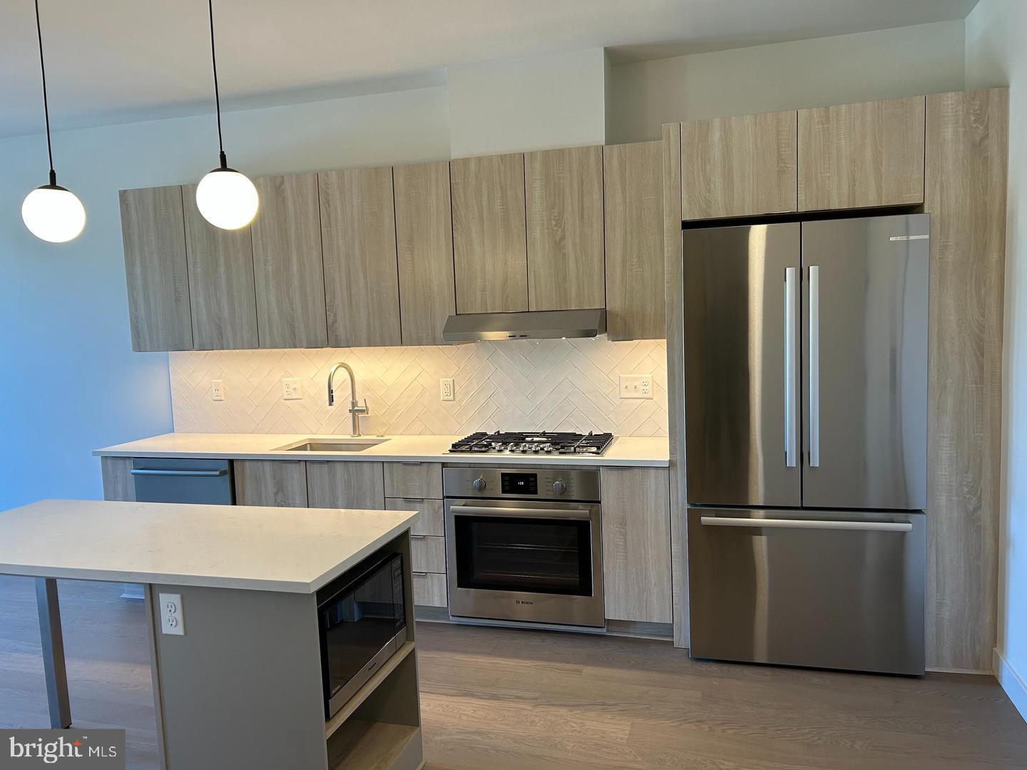 a kitchen with a stove a refrigerator and a sink