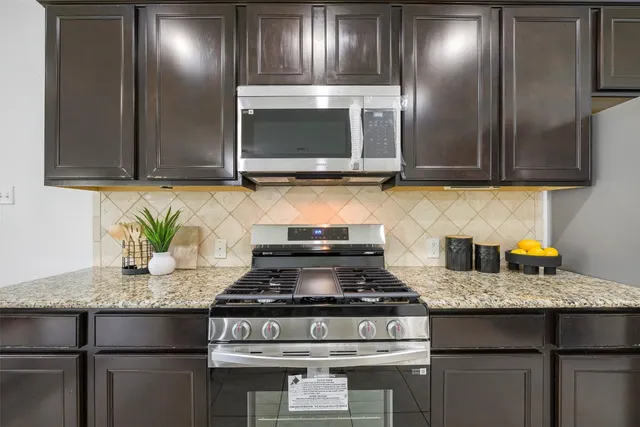 a kitchen with granite countertop stainless steel appliances and cabinets