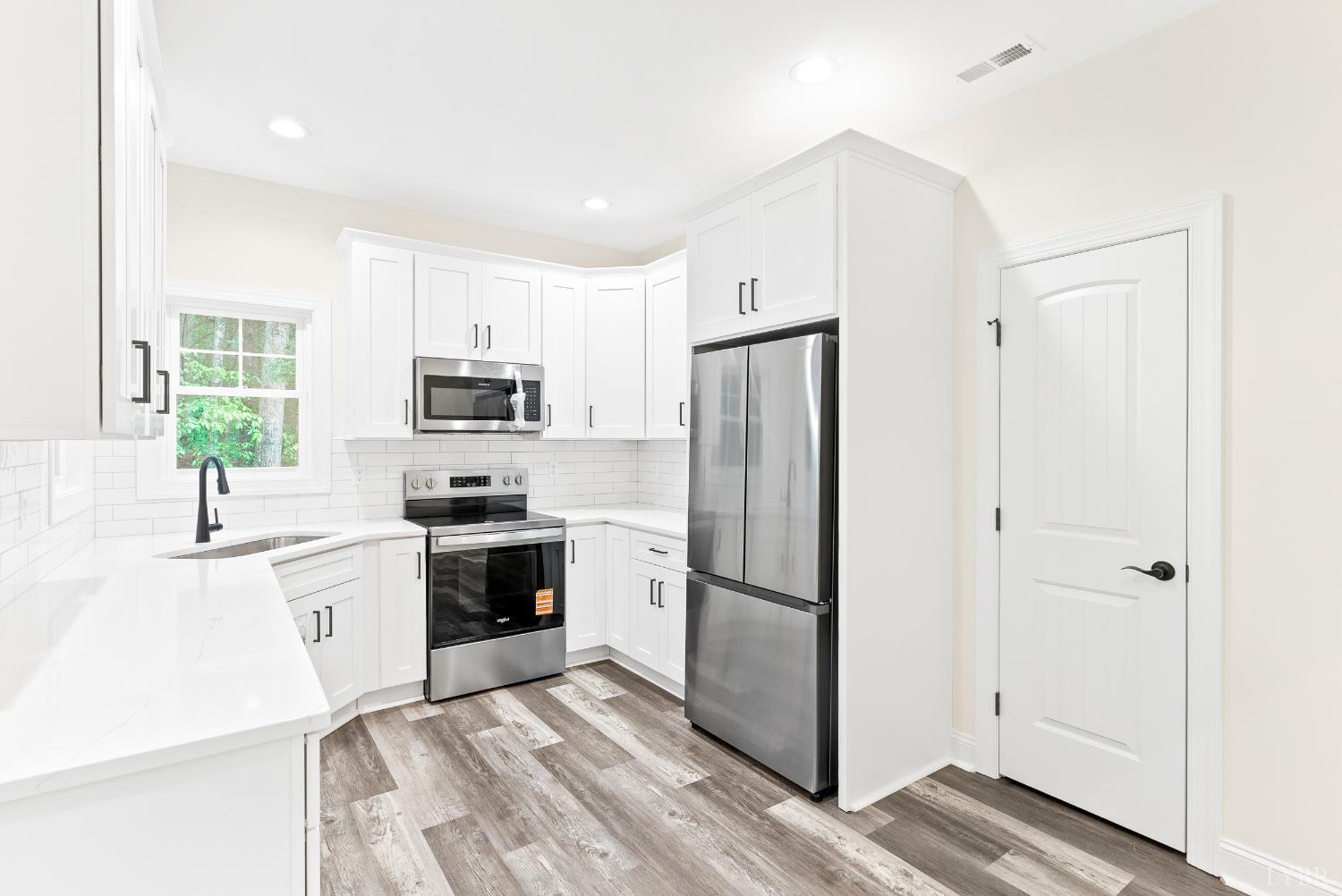 5610 Old Cifax Road Goode, VA 24556 - Photo 14 of 49 a kitchen with white cabinets and stainless steel appliances