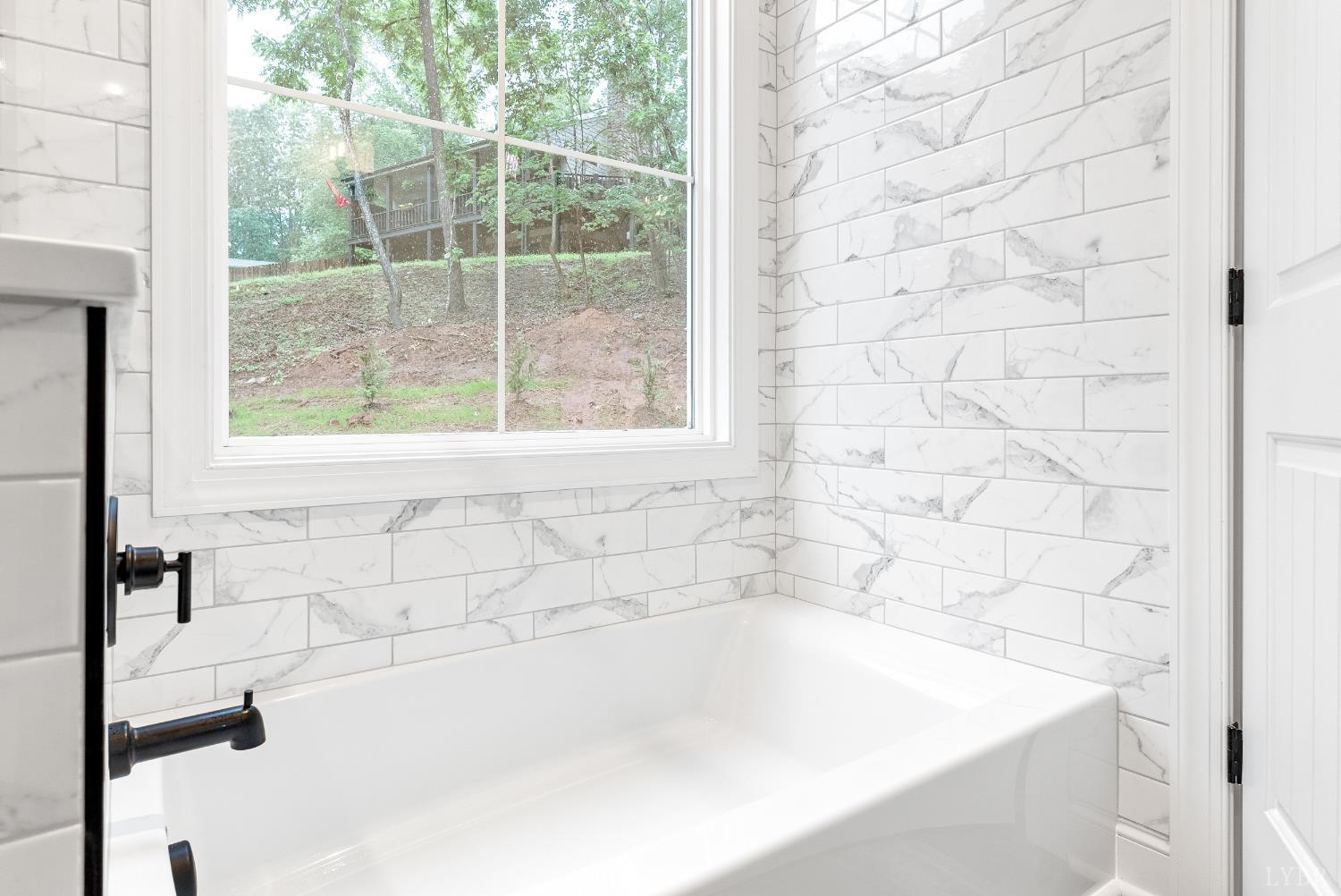 5610 Old Cifax Road Goode, VA 24556 - Photo 20 of 49 a white bath tub sitting in a bathroom next to a window