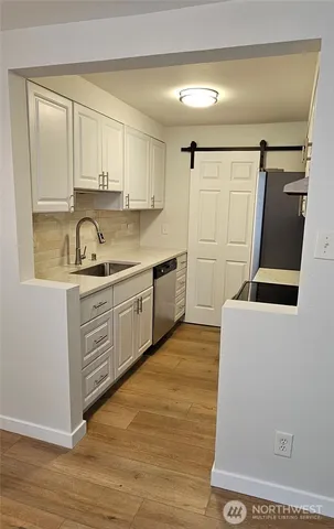 a kitchen with sink a refrigerator and cabinets