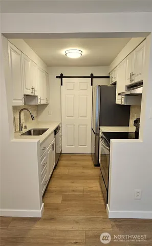 a kitchen with granite countertop a refrigerator and a sink