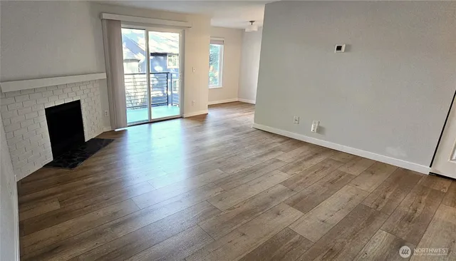 an empty room with wooden floor and fireplace
