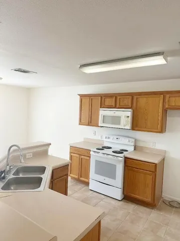 a kitchen with a stove sink and cabinets