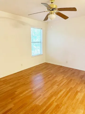 an empty room with a windows and ceiling fan