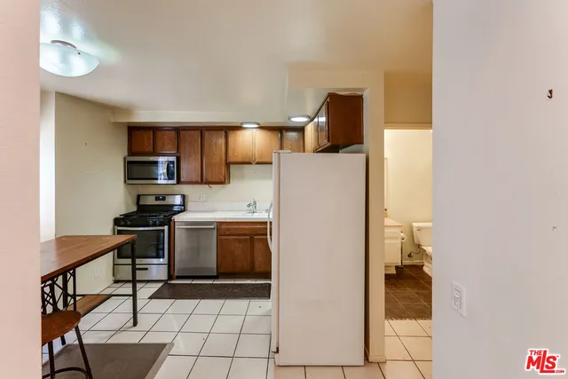 a kitchen with a refrigerator and a stove top oven