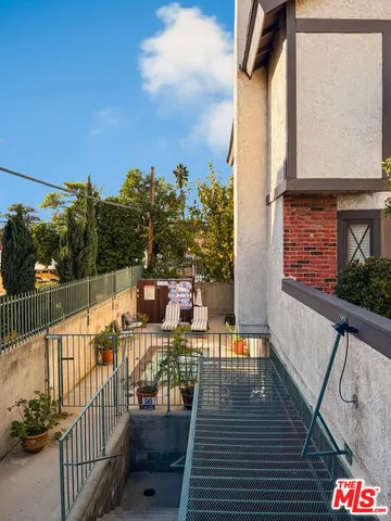 a balcony with wooden floor table and chairs