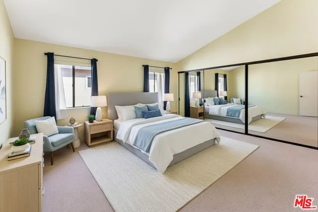 a bedroom with a bed couch and a large window