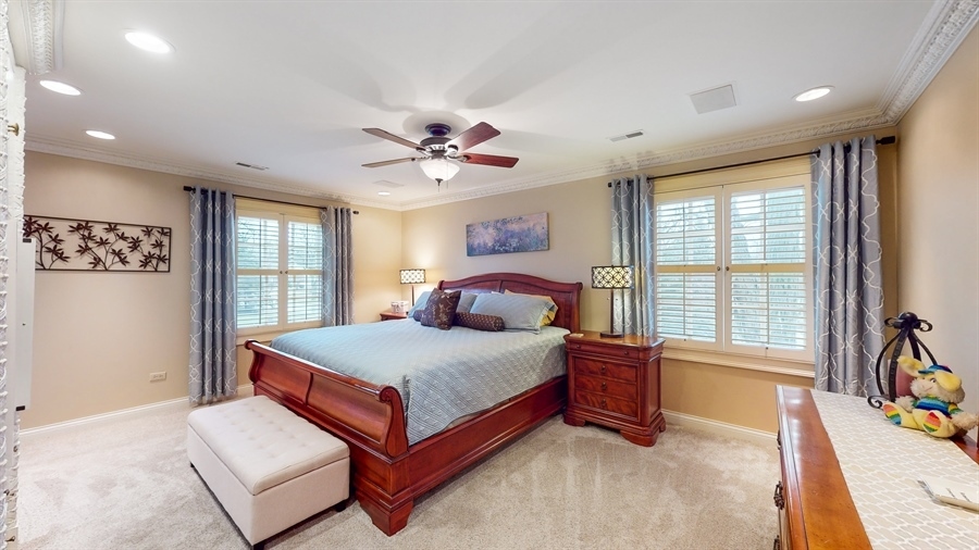 6 Knoll Ridge Road Rolling Meadows, IL 60008 - Photo 17 of 37 a bedroom with a large bed and a chandelier