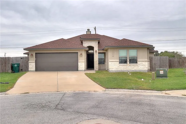 front view of a house with a yard and a garage