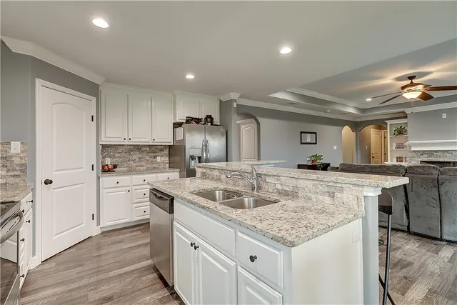 a kitchen with stainless steel appliances granite countertop a sink stove and refrigerator