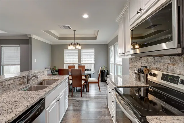 a kitchen with stainless steel appliances granite countertop a sink stove and microwave