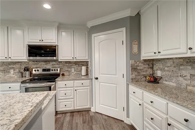 a kitchen with white cabinets and appliances