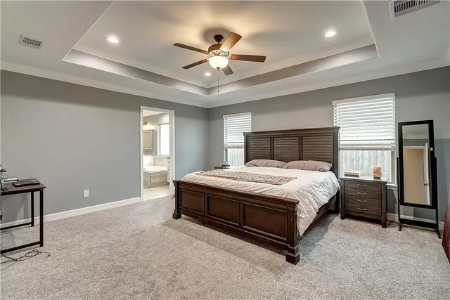 a spacious bedroom with a bed and ceiling fan