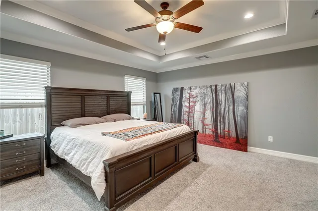 a bed sitting in a bedroom next to a window and a chandelier