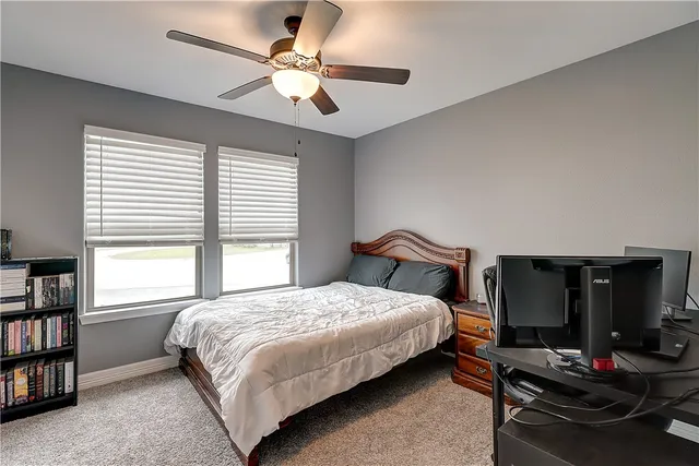 a bedroom with a bed gym equipment and a large window