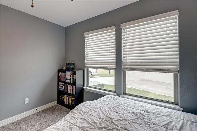 a bedroom with a bed and a large window