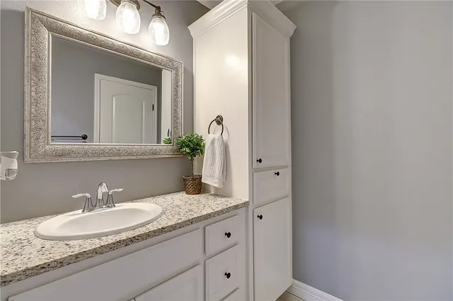 a bathroom with a granite countertop sink and a mirror