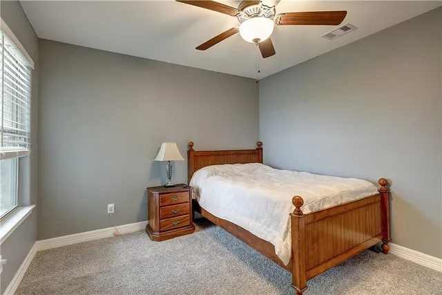 a bed sitting in a bedroom next to a window