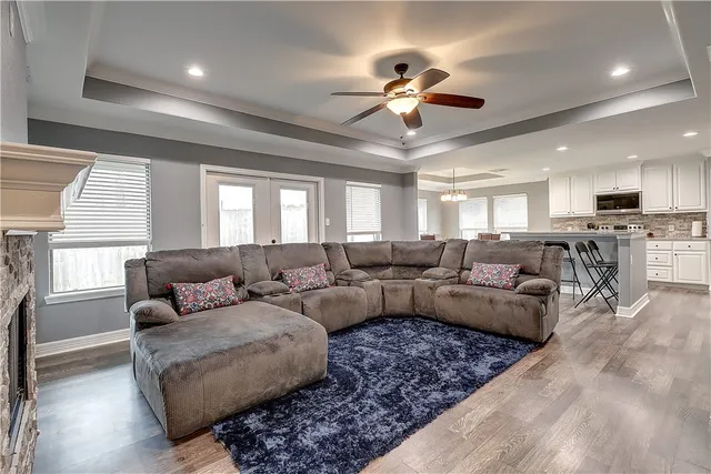 a living room with furniture kitchen view and a large window