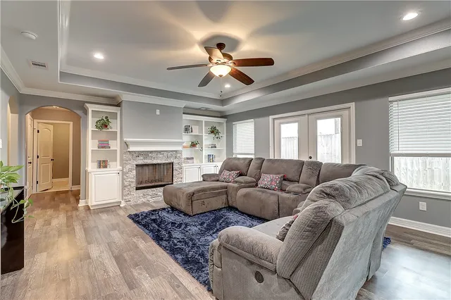 a living room with furniture a fireplace and a chandelier