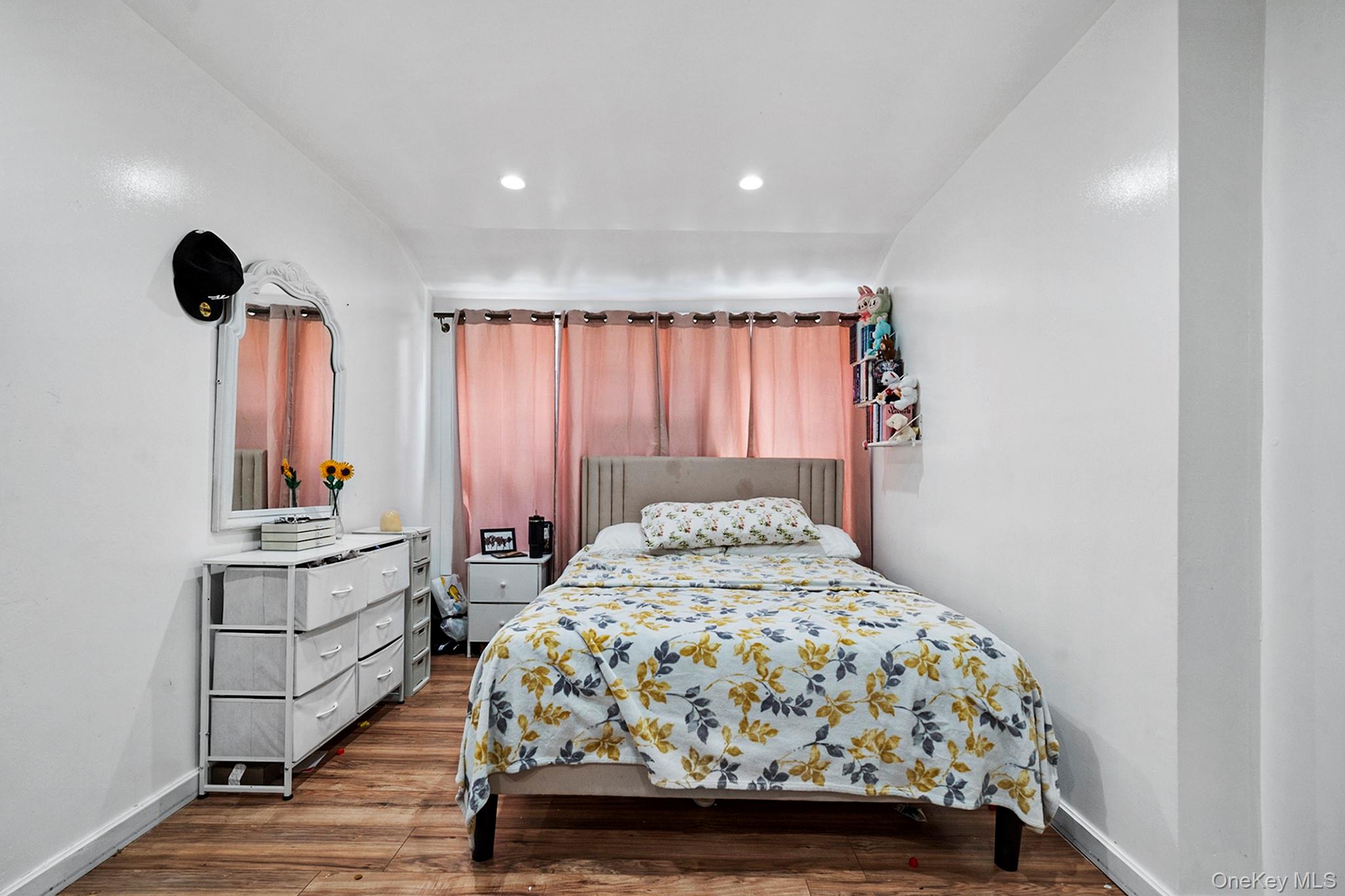 107-50 90th Street Queens, NY 11417 - Photo 7 of 9 a bedroom with a bed and a chandelier