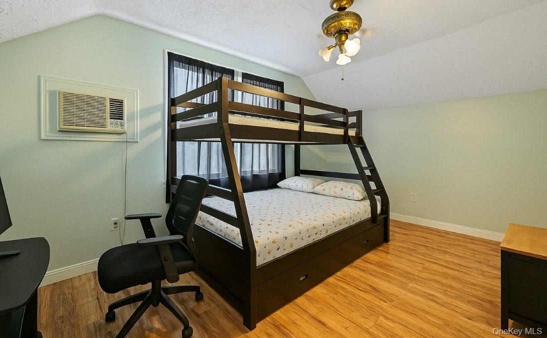 107-50 90th Street Queens, NY 11417 - Photo 8 of 9 a bedroom with a bed windows and a chandelier