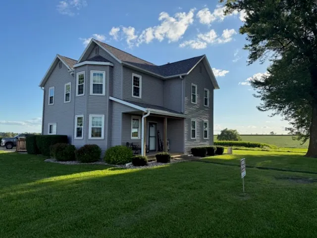 a front view of a house with a yard and trees