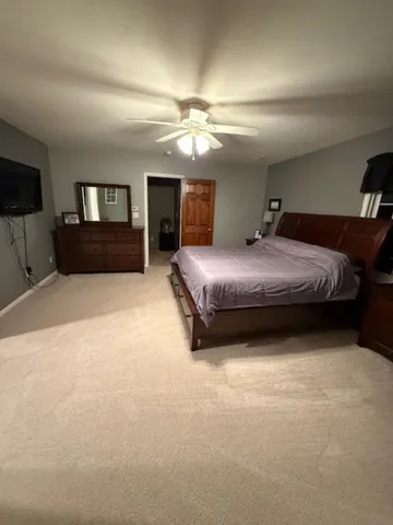 a spacious bedroom with a bed and a television