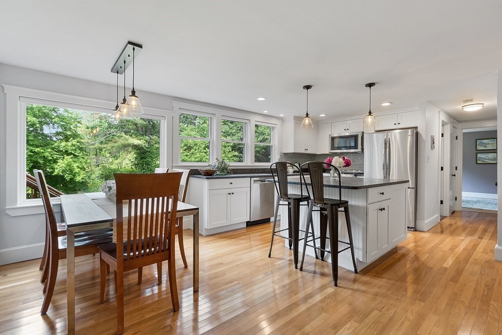 41 Gleasondale Road Stow, MA 01775 - Photo 10 of 42 a kitchen with stainless steel appliances granite countertop a stove top oven a sink dishwasher a dining table and chairs with wooden floor
