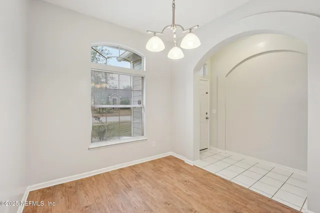 an empty room with a window and a ceiling fan