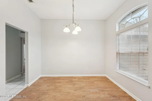 a view of a yard in front of a house with a large tree